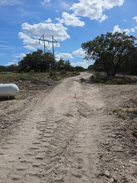Graded dirt access road under power lines near Big Lake, TX